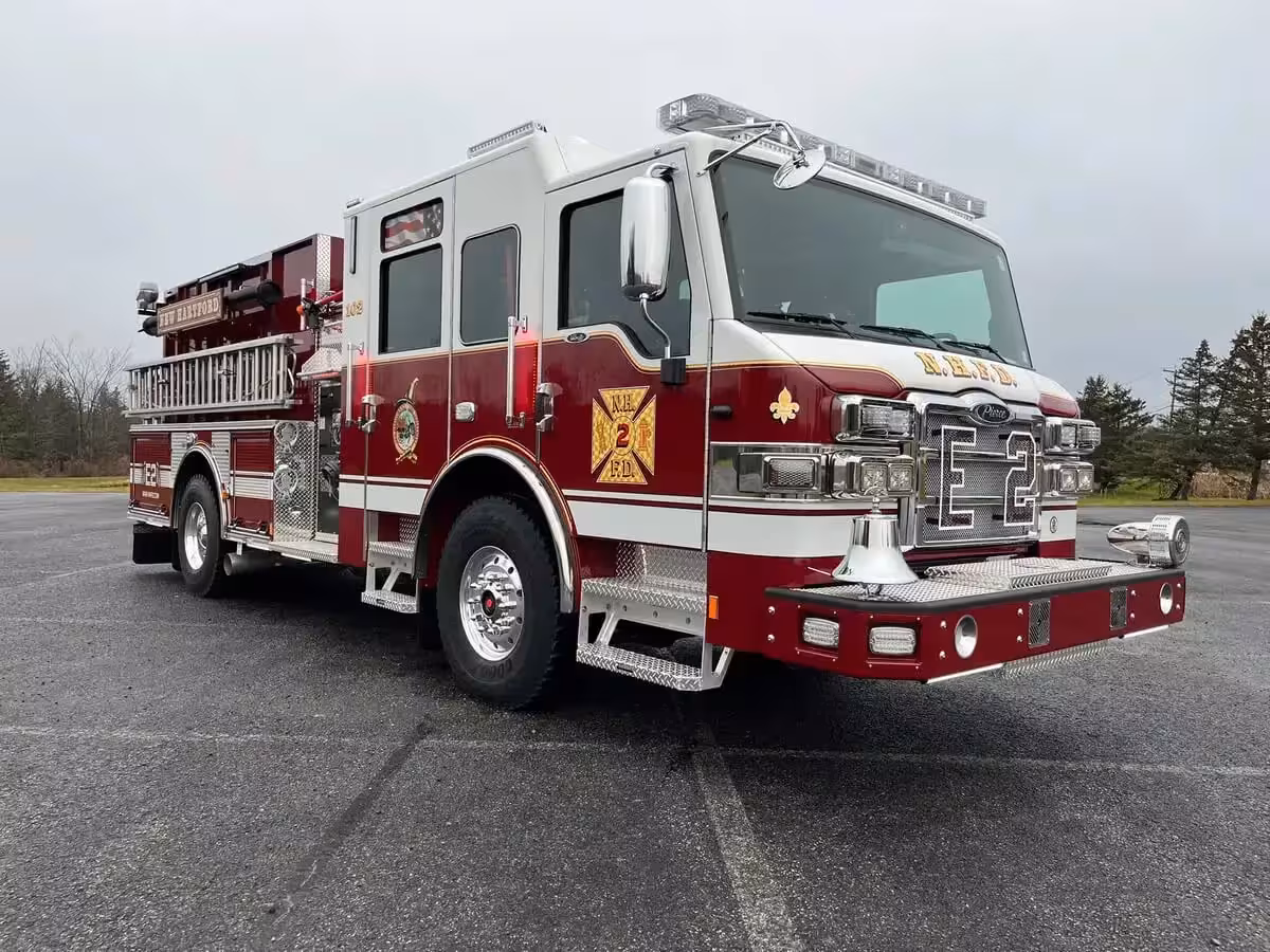 Pumper front-right exterior view showing bumper-mounted siren, grille, and crew cab