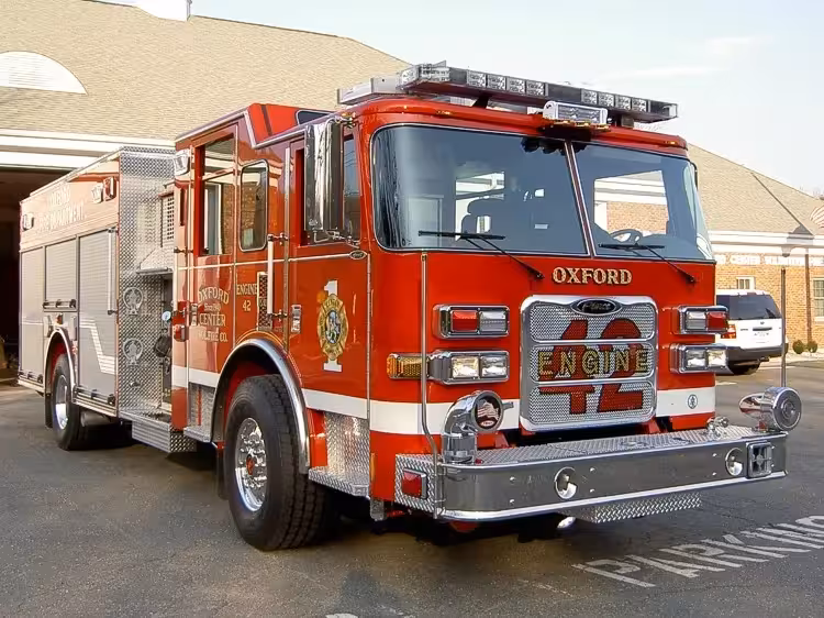 Pumper front-left exterior view showing enclosed cab, bumper, and side compartments
