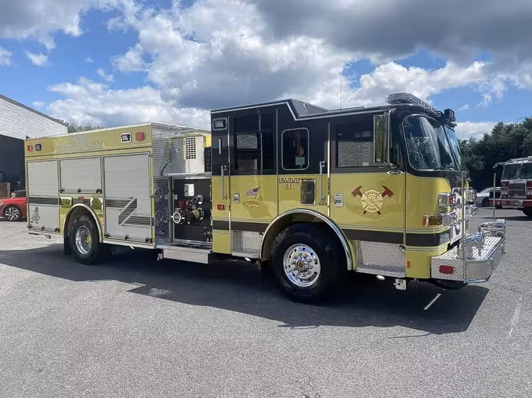 Rescue pumper front-left exterior view showing yellow body and enclosed cab