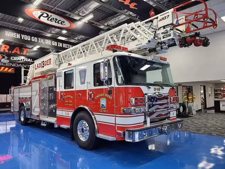 Tower ladder truck front-left exterior view showing cab and ladder bed