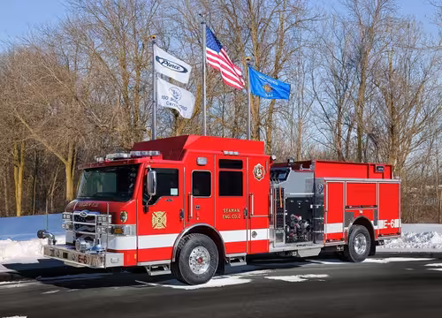 Front-left profile of a second red pumper showing side pump controls and rear body compartments.