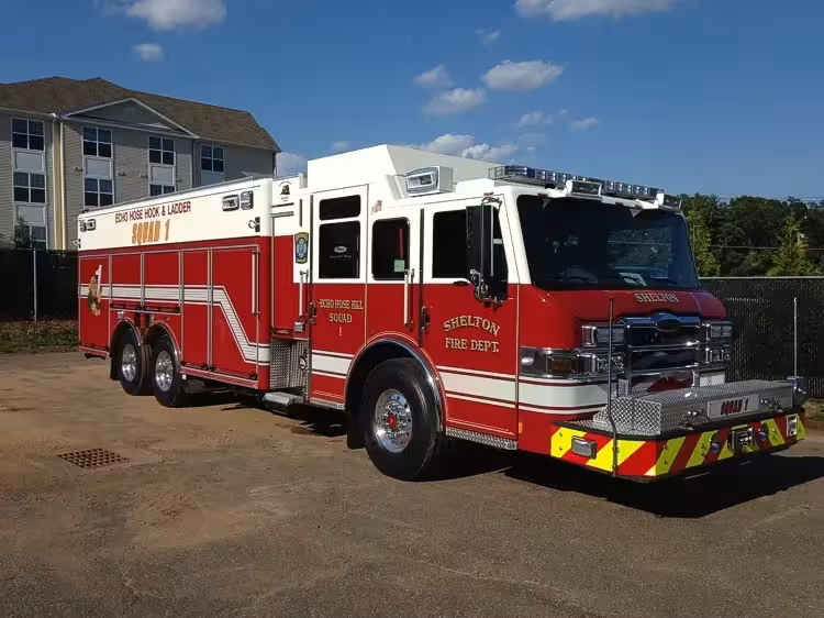 Heavy rescue pumper front-left exterior view showing tandem rear axles and long body
