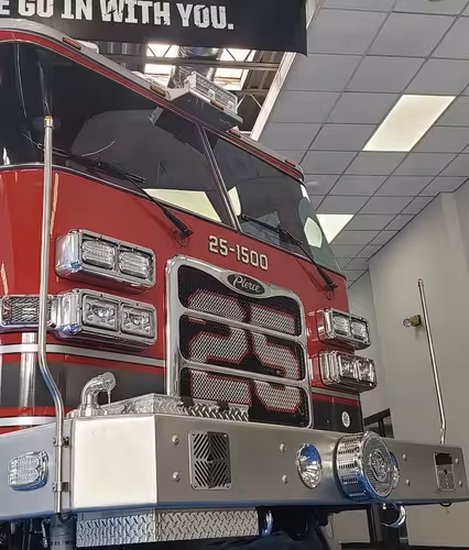 Front-left close-up indoors showing grille, bumper, and cab corner
