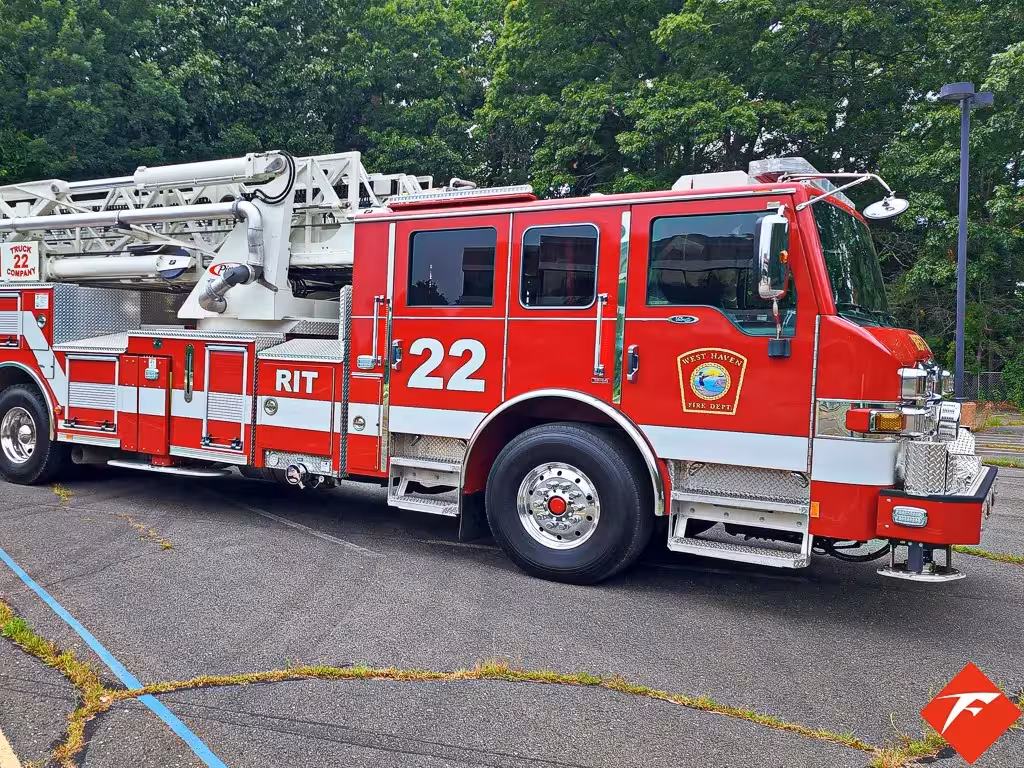 Tower ladder truck driver-side profile view showing aerial ladder and side body
