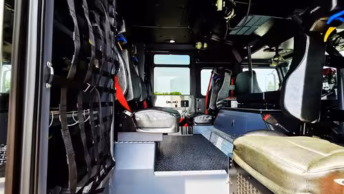Rear crew interior view showing seat row and gear rack