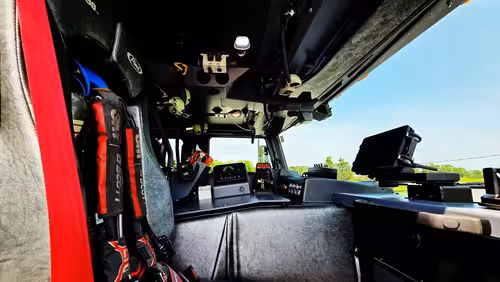 Cab interior wide view showing center console, front seats, and windshield