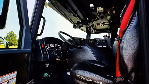 Driver cockpit view showing steering wheel, dashboard, and center controls