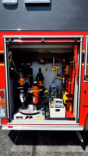 Open side compartment showing mounted hydraulic rescue tools and hand tools