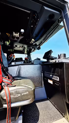Cab interior side view showing front seat, dash mounts, and console
