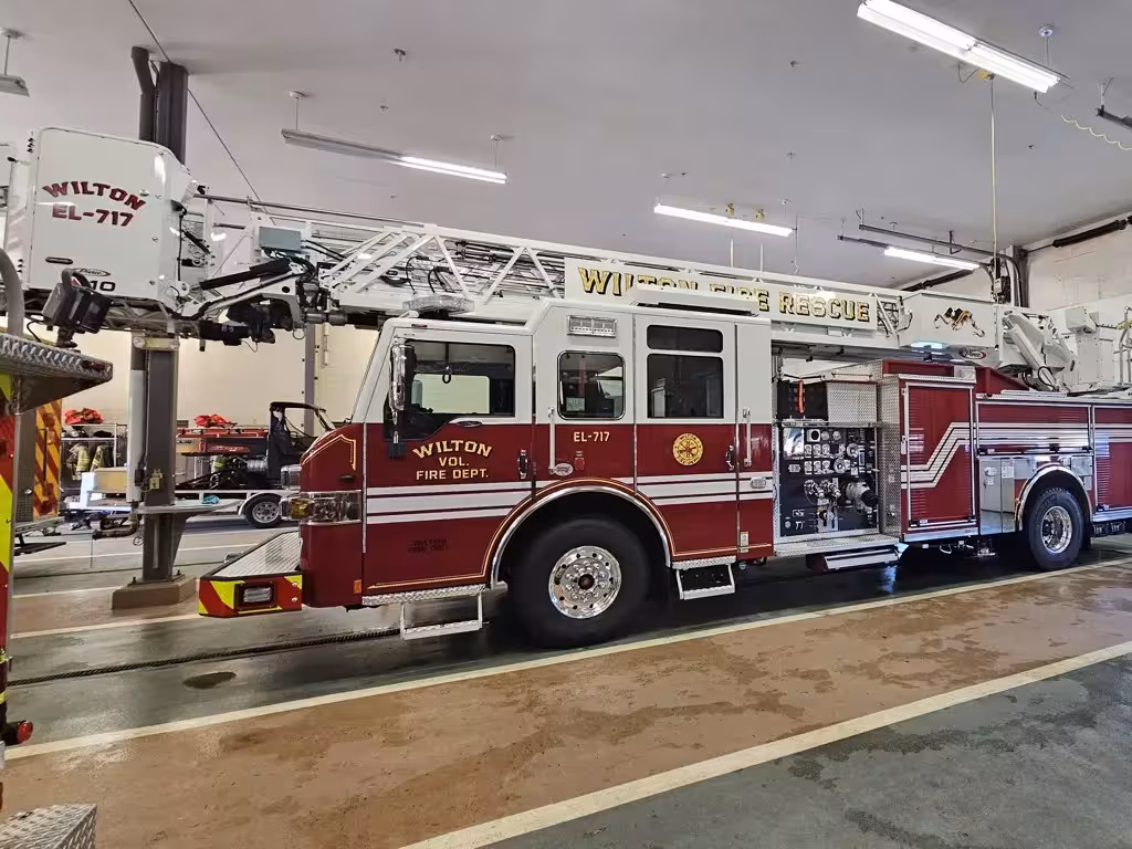 Tower ladder truck driver-side profile view showing aerial ladder and side body