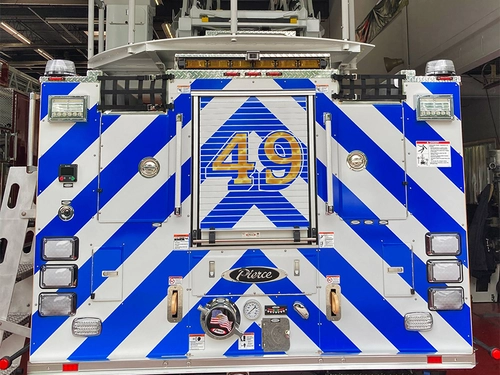 Rear view showing blue-and-white chevron striping, rear warning lights, and bucket above