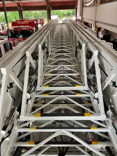 Top view along aerial ladder sections showing rungs and extension rails