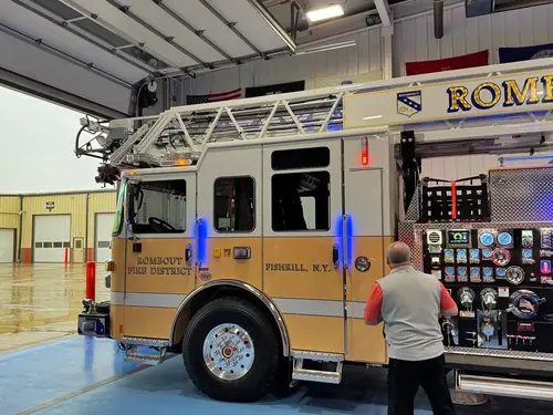 Driver-side cab and pump panel view with emergency lights illuminated
