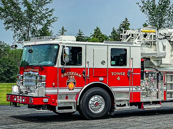 Tower ladder truck front-left exterior view showing aerial sections and cab