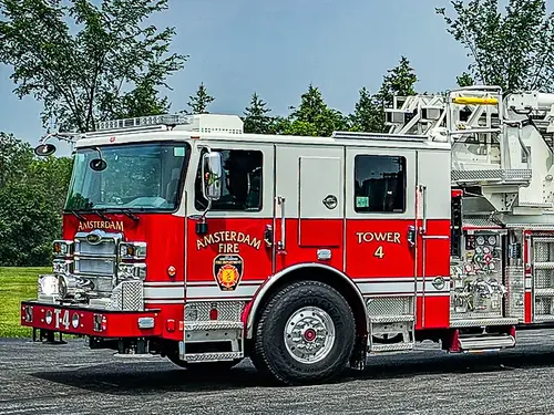 Tower ladder truck front-left exterior view showing aerial sections and cab