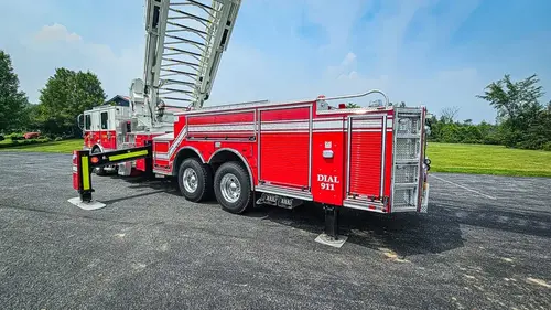 Rear-left profile showing tandem wheel area and lower body compartments