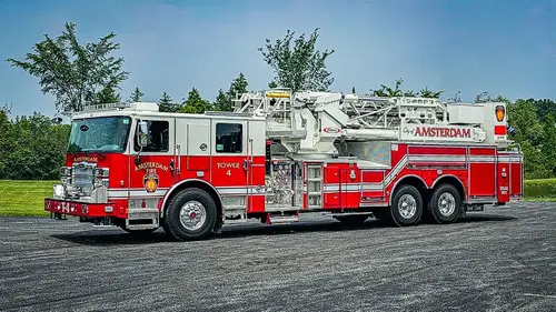 Driver-side full profile showing ladder bed and tandem rear axles