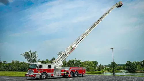 Tower ladder truck with aerial raised in parking lot
