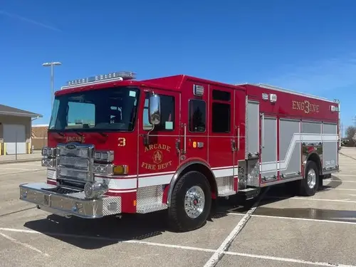 Pumper front-left exterior view showing chrome bumper, cab, and side compartments