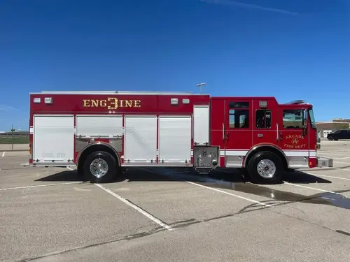 Pumper driver-side profile view showing exposed pump panel and side compartments