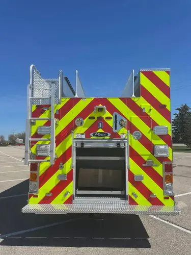 Rear view showing chevron striping, rear ladder, and open rear compartment
