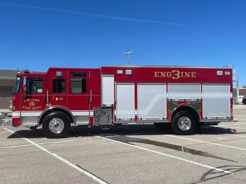 Pumper officer-side profile view showing pump panel area and closed compartment doors