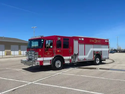 Pumper front-left wide view parked in lot showing cab and body compartments