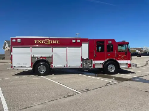 Pumper officer-side full profile view with closed roll-up compartment doors