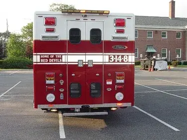 Straight rear view showing rear double doors, warning lights, and rear connection panel hardware.