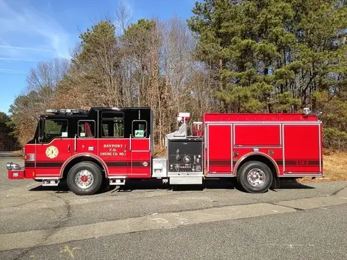 Driver-side full profile showing pump panel controls, side compartments, and wheelbase.