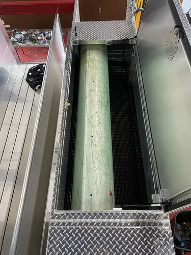 Open upper compartment showing cylindrical tube and divider rails in storage bay