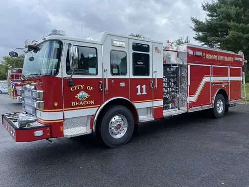 Driver-side profile view showing pumper body and side panel striping