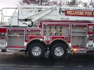 Driver-side profile showing tower ladder body and tandem rear axles