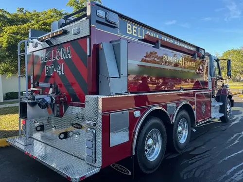 Rear-left exterior view showing tanker body, tandem axles, and rear compartments