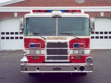 Head-on front view showing grille, warning lights, and bumper in front of station bays