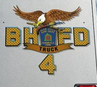 Close-up of a side logo panel with eagle artwork and unit number on the rear bucket section.