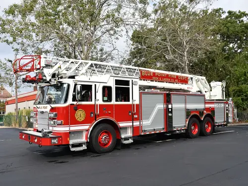 Tower ladder truck front-left exterior view showing aerial ladder and cab
