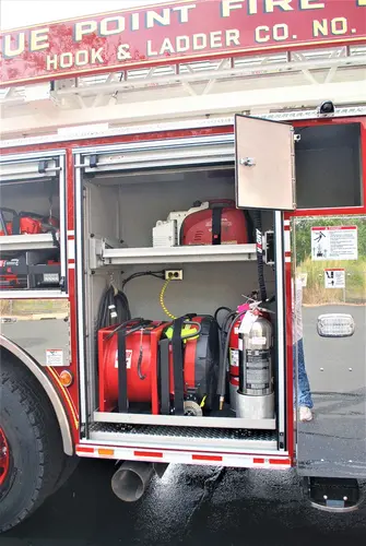 Open side compartment showing extinguishers and tool storage bins