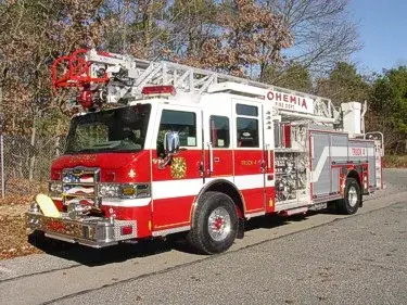 Front-right wide view showing the cab, side pump panel, wheel area, and rear body compartments.