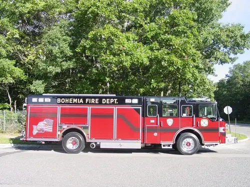 Driver-side full profile showing the long rescue body compartments, cab doors, and wheel layout.