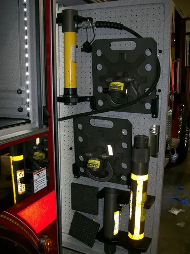 Open side compartment showing mounted extrication tools and brackets