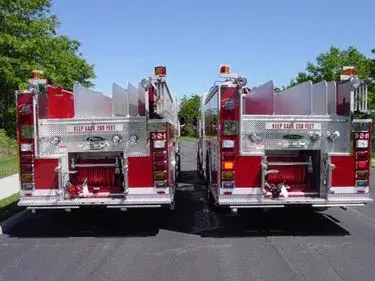 Rear view showing two pumpers from tailboard side with rear chevrons
