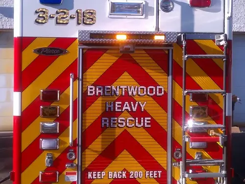 Close-up of the rear door with red-yellow chevrons, warning lights, and access ladder.