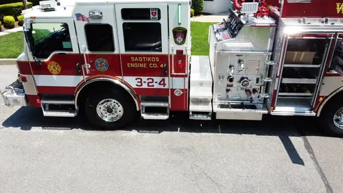 Pierce pumper aerial close side view of cab, pump panel section, and open compartments