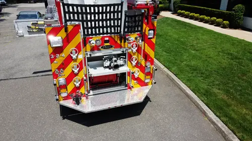 Pierce pumper aerial rear view showing chevron striping and rear hose connections