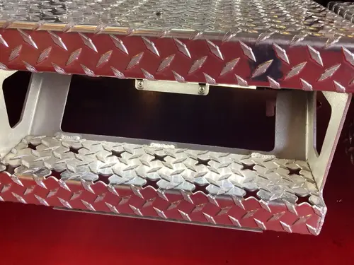 Pump panel lower tray close-up with diamond-plate pull handle