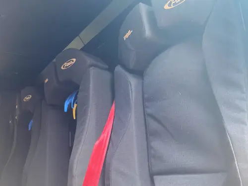 Rear crew seating close-up showing contoured seatbacks and safety restraints