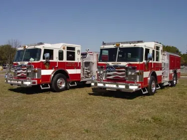 Two pumpers front-left lineup view showing grilles, bumpers, and side compartments