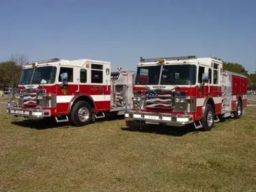 Two pumpers front-left lineup view showing grilles, bumpers, and side compartments