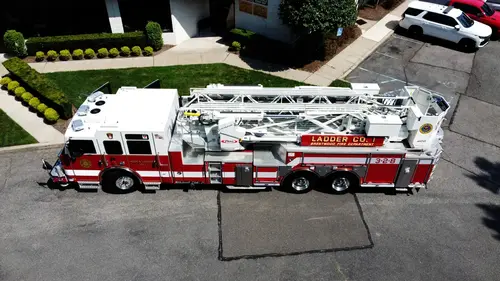 Pierce tower ladder elevated driver-side profile with cab and body compartments visible